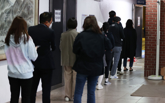 2021 재·보궐선거 투표일인 7일 저녁 서울 강남구 단국대학교 사범대학 부속고등학교 체육관에 마련된 대치1동 제1투표소를 찾은 시민들이 투표를 하기 위해 줄을 서 있다. <연합뉴스>